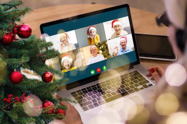 Atölyesindeki dizüstü bilgisayarında çeşitli mutlu çocukların olduğu bir video görüşmesi. Ev kavramında kişisel izolasyon ve sanal online kutlama. Noel