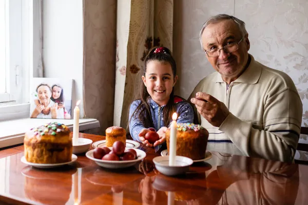 행복 한 할아버지와 손녀 손에는 설화 알을 들고 있고, 민속 게임은 설화 알을 뛰고 있다 — 스톡 사진