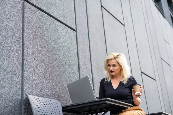 Foto recortada de uma mulher com laptop colocado na mesa — Fotografia de Stock