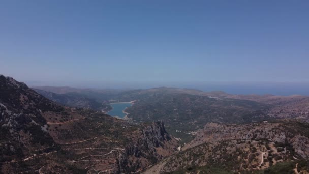 Naturaleza aérea Paisaje griego con mar, montaña, olivos y casas en Creta. Destino de vacaciones y turismo en verano. — Vídeos de Stock