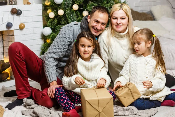 幸せな若い家族がクリスマスプレゼントを持って笑顔で — ストック写真