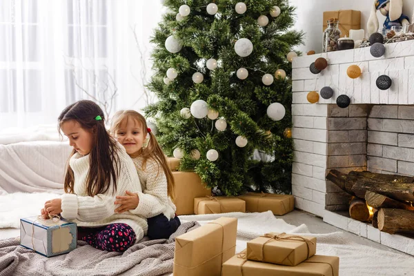 Twee kleine meisjes delen een verrassing op kerstochtend — Stockfoto