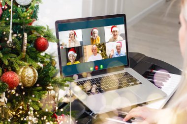 Atölyesindeki dizüstü bilgisayarında çeşitli mutlu çocukların olduğu bir video görüşmesi. Ev kavramında kişisel izolasyon ve sanal online kutlama. Noel