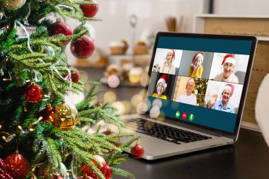 Atölyesindeki dizüstü bilgisayarında çeşitli mutlu çocukların olduğu bir video görüşmesi. Ev kavramında kişisel izolasyon ve sanal online kutlama. Noel