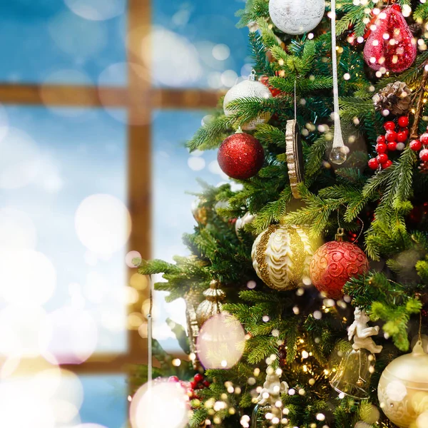 Primer plano de la bola roja colgando de un árbol de Navidad decorado — Foto de Stock