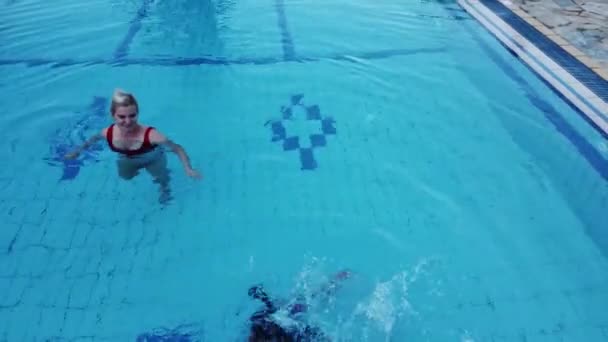 Madre e hija jugando en una piscina — Vídeos de Stock
