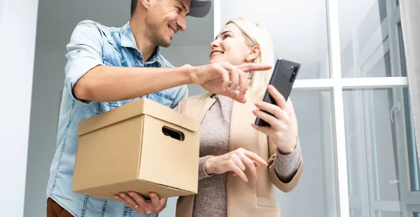 Joven hombre guapo entrega caja. — Foto de Stock