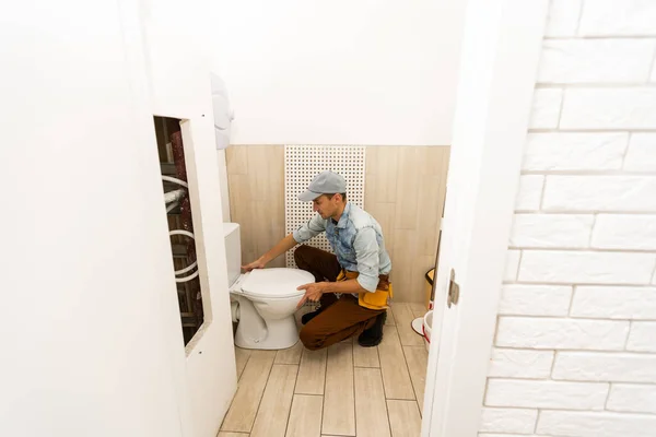 Fontanero con un émbolo de inodoro. El trabajador —  Fotos de Stock