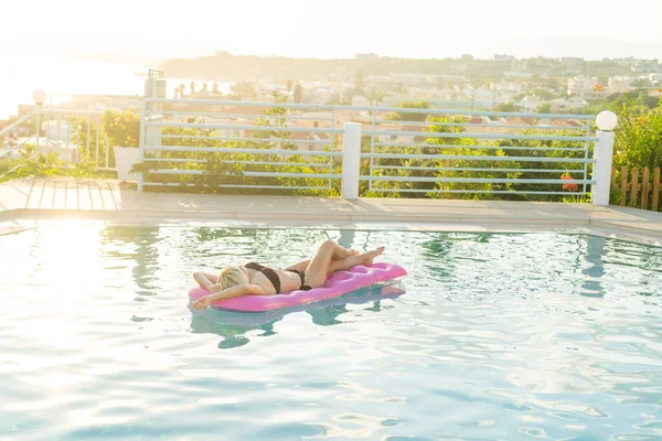 Giovane bella donna sul materasso ad aria in piscina — Foto Stock