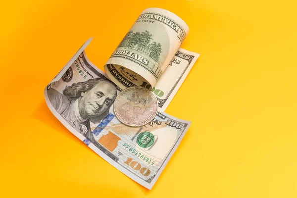 Bitcoins dorés et argentés et billets de cent dollars sur bureau en bois — Photo