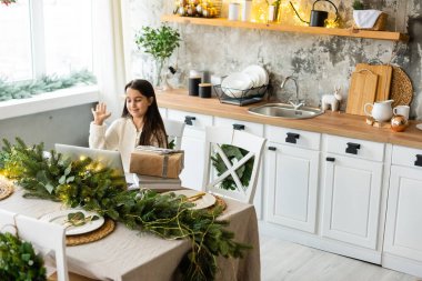 Noel tatilinde ailesiyle görüntülü konuşma yapan mutlu küçük kız. Sanal sohbet konferansında Noel arifesini kutlayan çocuk.