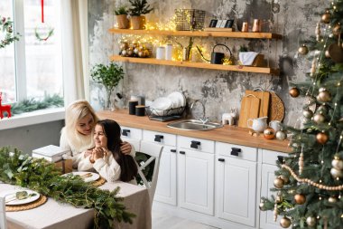 Anne ve çocuk Noel ağacı sarılmak.