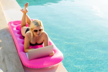 güneşlenme ve açık havada havuzu yakındaki bir şezlong üzerinde seksi kadın