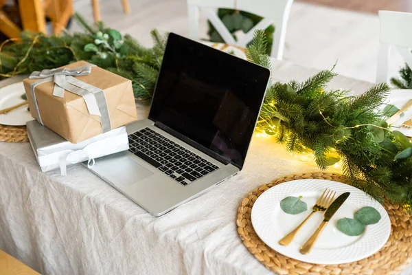Laptop met geschenkdoos en kerstverlichting achtergrond — Stockfoto