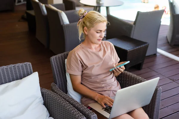 Νεαρή γυναίκα που κάθεται στον καναπέ στο λόμπι ξενοδοχείο εργασίας φορητού υπολογιστή — Φωτογραφία Αρχείου
