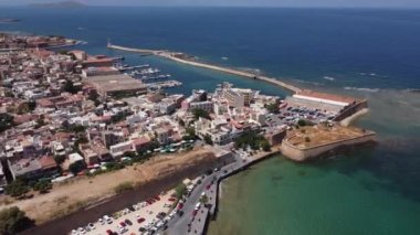 Girit, Yunanistan. Ön planda - Heraklion limanının deniz ve iskelesi, yükleme ekipmanları, yolcu gemileri, yatlar, arka planda