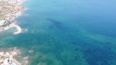 İnsansız hava aracının su altı resiflerindeki görüntüsü ve Akdeniz kıyısındaki şeffaf suyla birlikte plajların yakınındaki kayalıklar. Kamera aşağı bakıyor. Girit, Yunanistan.