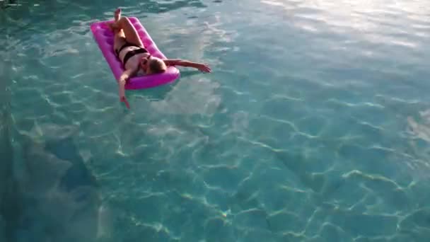 Νεαρή όμορφη γυναίκα σε στρώμα αέρα στην πισίνα — Αρχείο Βίντεο