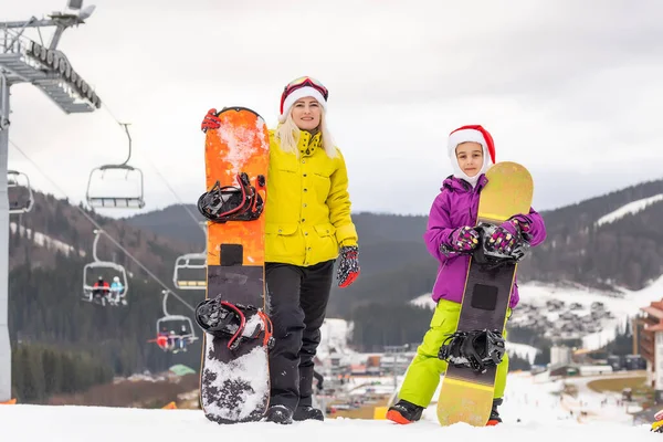 Portré boldog család Mikulás sapkák és snowboard téli üdülőhelyen — Stock Fotó