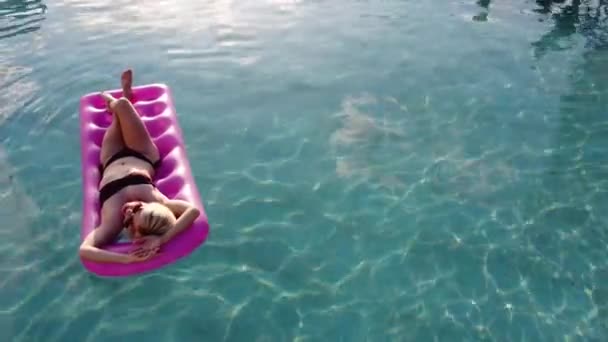Молода красива жінка з ідеальним тілом лежить на повітряному матраці — стокове відео