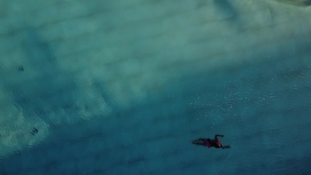 Menina sorridente em óculos de natação nadando debaixo d 'água na piscina. Adolescente menina mergulho subaquático — Vídeo de Stock