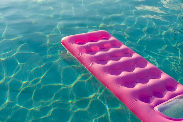 Matelas rose dans la piscine journée ensoleillée — Photo