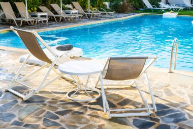 Yüzme havuzunun yanında güneşlenirler..