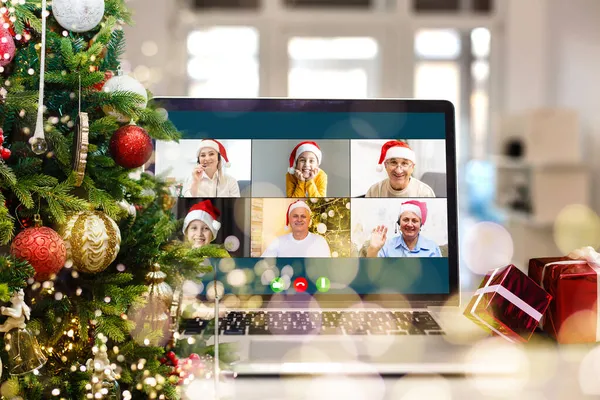 video call with happy diverse children on laptop computer in his workshop. Self-isolation and virtual online celebration at home concept. Christmas