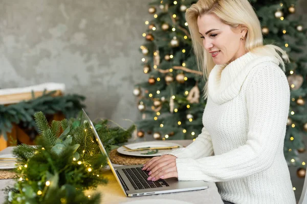 Улыбающаяся молодая женщина делает рождественские покупки в Интернете — стоковое фото