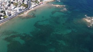 İnsansız hava aracının su altı resiflerindeki görüntüsü ve Akdeniz kıyısındaki şeffaf suyla birlikte plajların yakınındaki kayalıklar. Kamera aşağı bakıyor. Girit, Yunanistan.