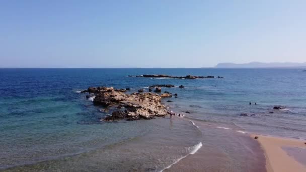 İnsansız hava aracının su altı resiflerindeki görüntüsü ve Akdeniz kıyısındaki şeffaf suyla birlikte plajların yakınındaki kayalıklar. Kamera aşağı bakıyor. Girit, Yunanistan. — Stok video