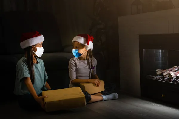 Noel Baba şapkalı çocuk Noel hediyesi kutulu tıbbi yüz maskesi takıyor. Noel alışverişi. Boşluğu kopyala. — Stok fotoğraf