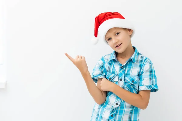 Noel Baba kılığındaki çocuk beyaz bir şeyi işaret ediyor. — Stok fotoğraf