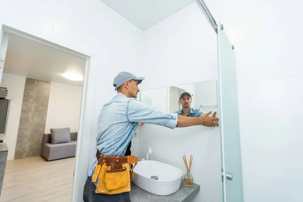 Handyman installazione specchio in bagno. — Foto Stock
