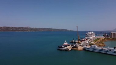 Girit, Yunanistan. Ön planda - Heraklion limanının deniz ve iskelesi, yükleme ekipmanları, yolcu gemileri, yatlar, arka planda