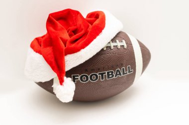 Beyaz arka planda rugby topu olan Noel Baba şapkası