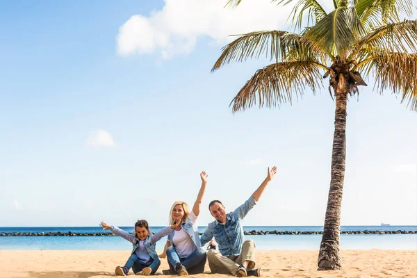 Gelukkig familie handen omhoog op het strand — Stockfoto