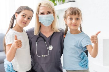 Doktor ve iki küçük kız hasta.