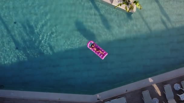 Kleines Mädchen schwimmt auf aufblasbarer Matratze im Pool — Stockvideo