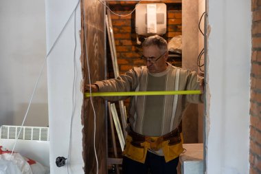 gri saçlı tamirciyle ölçüm duvar