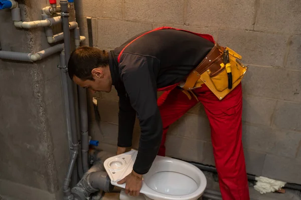 Concepto de edificio, profesión y personas - constructor o fontanero que trabaja con tuberías de agua en la sala de calderas —  Fotos de Stock