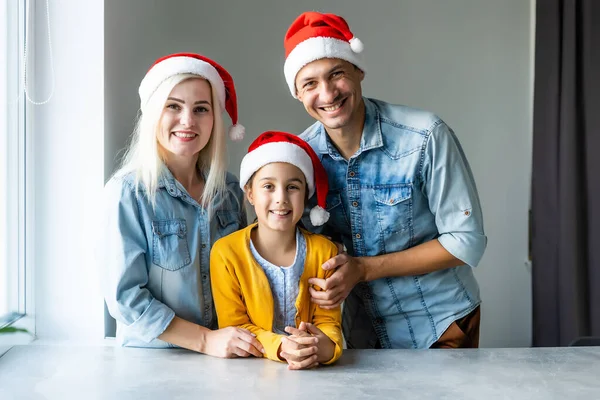 Aile, Noel, Noel, Noel, kış, mutluluk ve insanların konsepti - Noel Baba şapkalı gülümseyen aile — Stok fotoğraf