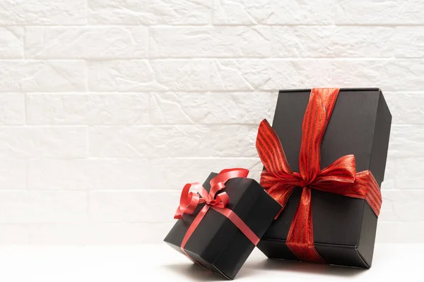 Cadeau met een rood lint. Zwarte geschenkdoos — Stockfoto