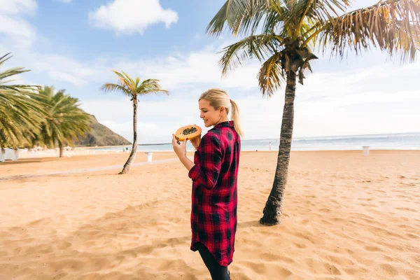 Frau hält Papaya am Strand — Stockfoto