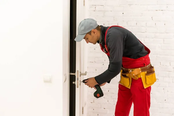 Hombre fijación de cerraduras con destornillador en una casa nueva — Foto de Stock