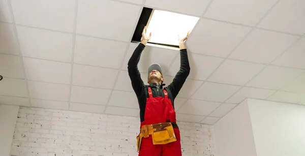 Um construtor substituindo painel de teto, trabalhando, armstrong. — Fotografia de Stock
