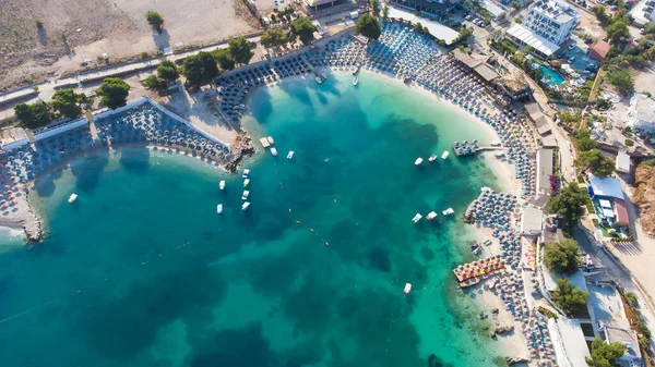 Arnavutluk 'un güzel Ksamil plajında güneşlik şemsiyeler ve şezlonglar.