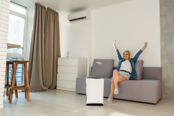 Luftrenare i vardagsrummet för ren och frisk luft med kvinna — Stockfoto