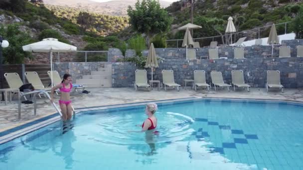 Vacker kvinna med sin dotter i poolen — Stockvideo