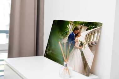 Ahşap çerçeveli bir galeride sergilenen fotoğraf örneği. Tuvale basılmış düğün fotoğrafı.